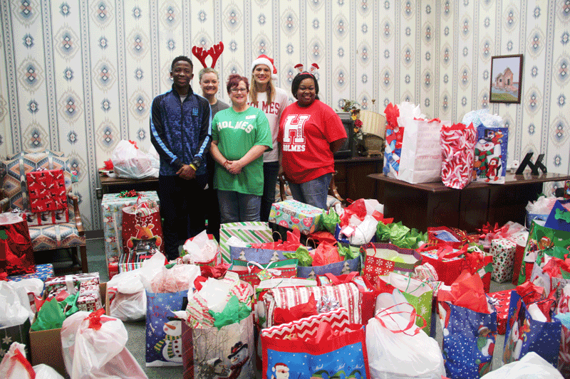 Representatives from the Holmes CC Ridgeland Campus delivered gifts collected by Rotoract. Pictured are (left to right) Holmes student Jaylon George, Head Librarian Blair Booker, Assistant Librarian Jennifer Smith, History and Political Science Department Chair Laura Canard, and Financial Aid Advisor Mary Haralson with some of the gifts collected.